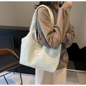 Gros plan du sac fourre-tout en peluche arc-en-ciel avec étiquette blanche et bandoulière