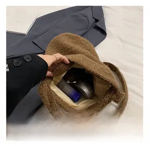 Internal capacity of the brown teddy fleece bucket bag showing cosmetics and shoulder strap