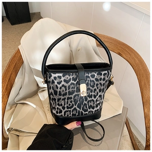 Detail of leopard print bucket bag with gold clasp closure and black leather trim
