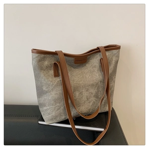 Detail of grey tote bag with brown leather straps and Fashion & Bags brand tag