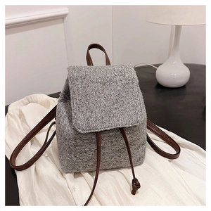 Détail du sac à dos en laine grise avec bretelles en cuir marron et cordon serrage