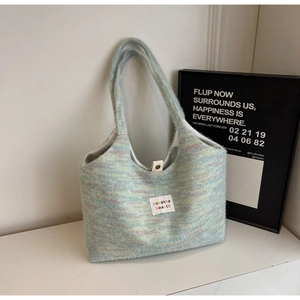 Détail du sac cabas en tricot arc-en-ciel avec texture douce et fermeture par bouton pression