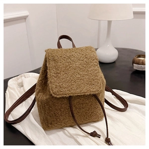 Détail du tissu en laine marron doux et de la sangle en cuir d'un sac à dos élégant