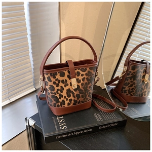 Detail of leopard print bucket bag with leather handles and detachable shoulder strap