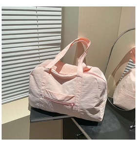 Detailed view of pink large capacity travel tote bag with front zipper pocket and dual handles
