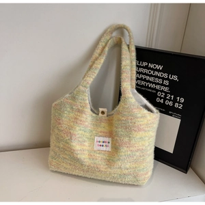 Détail du sac cabas en peluche arc-en-ciel montrant la texture douce et le fermoir métal