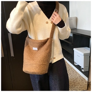 Detail view of brown faux shearling bucket bag with plush texture and Love Fashion label