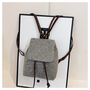 Détail d'un mini sac à dos en laine grise montrant la texture douce et la sangle en cuir