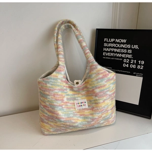 Gros plan du sac cabas en tricot rayé arc-en-ciel avec étiquette et fermoir magnétique