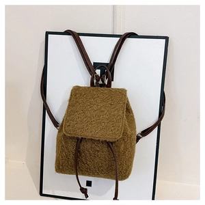 Détail du sac à dos en peluche marron avec cordon de serrage et bretelles en cuir