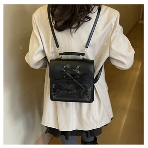 Detail of JK style black leather ita bag featuring transparent window and ribbon bow