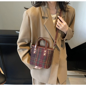 Detailed view of women retro plaid wool bucket bag with leather handles and gold hardware