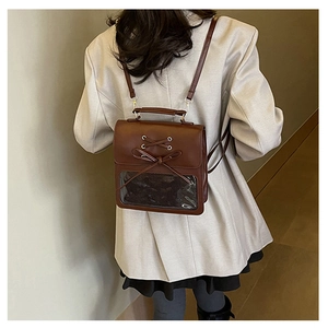 Close-up of vintage brown PU leather backpack with bow tie and clear window detail