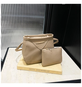 Détail d'un ensemble de sacs à main beige texture litchi avec finitions en métal doré