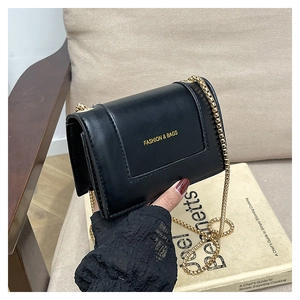 Close-up of black PU leather mini square bag with gold FASHION & BAGS logo and chain