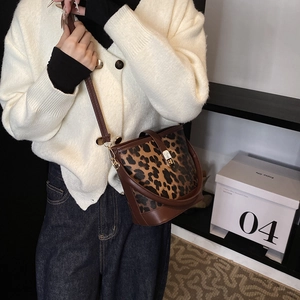 Chic leopard print bucket bag with leather handles and long adjustable shoulder strap