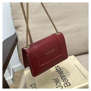 Detail view of retro red leather small square bag with gold chain and gold lettering