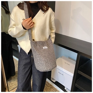 Detail of grey wool bucket bag with LOVE FASHION label and soft plush texture