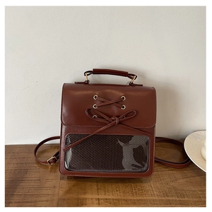 Detailed view of the bow tie decor and transparent window on the brown leatherita backpack
