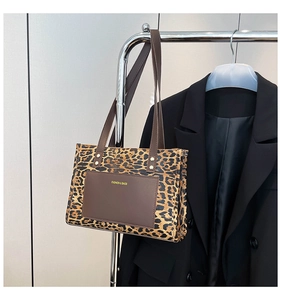 Detail of leopard print tote bag with brown leather patch and gold metal rivets