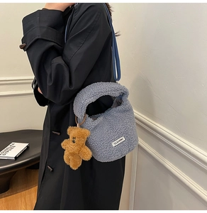 Blue lamb wool bucket bag with woven strap and a cute brown plush bear pendant