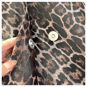 Detail of leopard print faux leather bag showing lychee grain texture and metal magnetic buckle