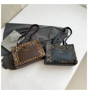 Detail of leopard print tote bags with front leather pocket and gold metal hardware