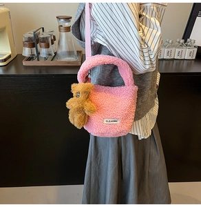 Pink plush lamb wool bucket bag with bear pendant and adjustable strap in use