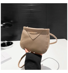 Détail d'un sac bandoulière beige en cuir grainé avec fermoir doré minimaliste chic