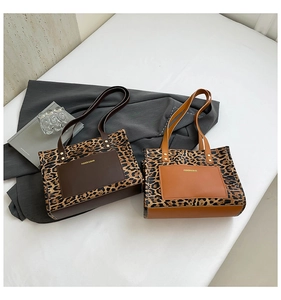 Detail of leopard print tote bags with front pockets and elegant gold fashion lettering