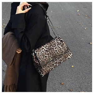 Detail of leopard print shoulder bag with gold chain strap on winter wool coat