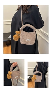 Detailed close-up of light brown teddy plush bucket bag with bear pendant and adjustable strap