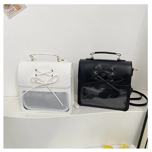 Detail view of black and white ita-bags featuring ribbon bows and transparent PVC windows