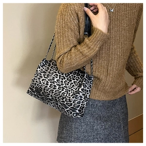 Close-up of leopard print shoulder bag featuring silver chain and leather strap design