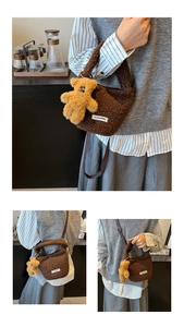 Detail of plush faux shearling bucket bag in brown featuring cute bear charm and strap