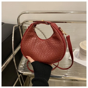 Detail of burgundy woven hobo bag showing faux leather texture and metallic buckle