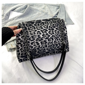 Detail of grey leopard print bag with silver metal chain and leather shoulder strap
