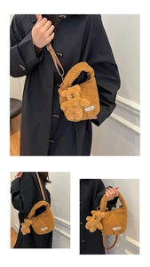 Detail of brown plush crossbody bucket bag featuring a cute teddy bear charm and logo tag