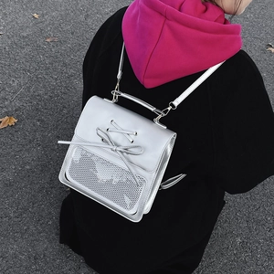 Silver metallic mini backpack with bow detail and mesh pocket in street style view