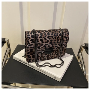 Detail of leopard print shoulder bag with black metal clasp and dark chain strap
