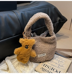 Detailed texture of brown plush bucket bag with a teddy bear charm on a sofa