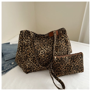 Detail of leopard print tote bag set with matching zippered clutch on white surface