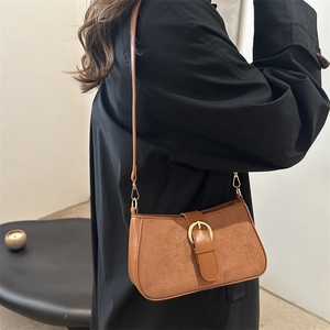 Retro brown suede hobo bag with gold hardware shown from a side view on a model