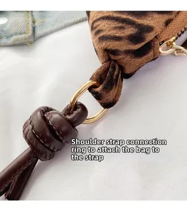 Macro detail of leopard print bag with shoulder strap D-ring and knotted leather trim
