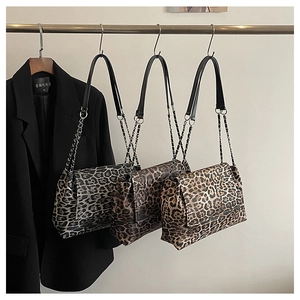 Three leopard print shoulder bags hanging with chain straps in multiple color tones