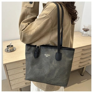 Dettaglio della borsa tote grigia opaca con logo dorato e fibbia in metallo regolabile