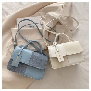 Dettaglio della borsa a tracolla bicolore blu e beige con texture a contrasto