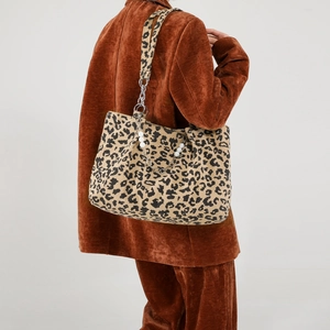 Sac cabas léopard en velours côtelé avec chaîne de perles porté par un mannequin femme