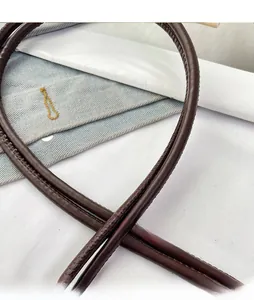 Macro detail of high-quality dark brown leather shoulder strap with neat stitching