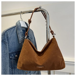 Detailed view of brown suede hobo bag with unique knot detail on the shoulder strap